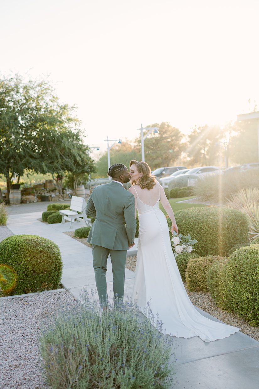 Las Vegas Portrait Photography, Bride and groom kiss while sun sets, green suit, white dress
