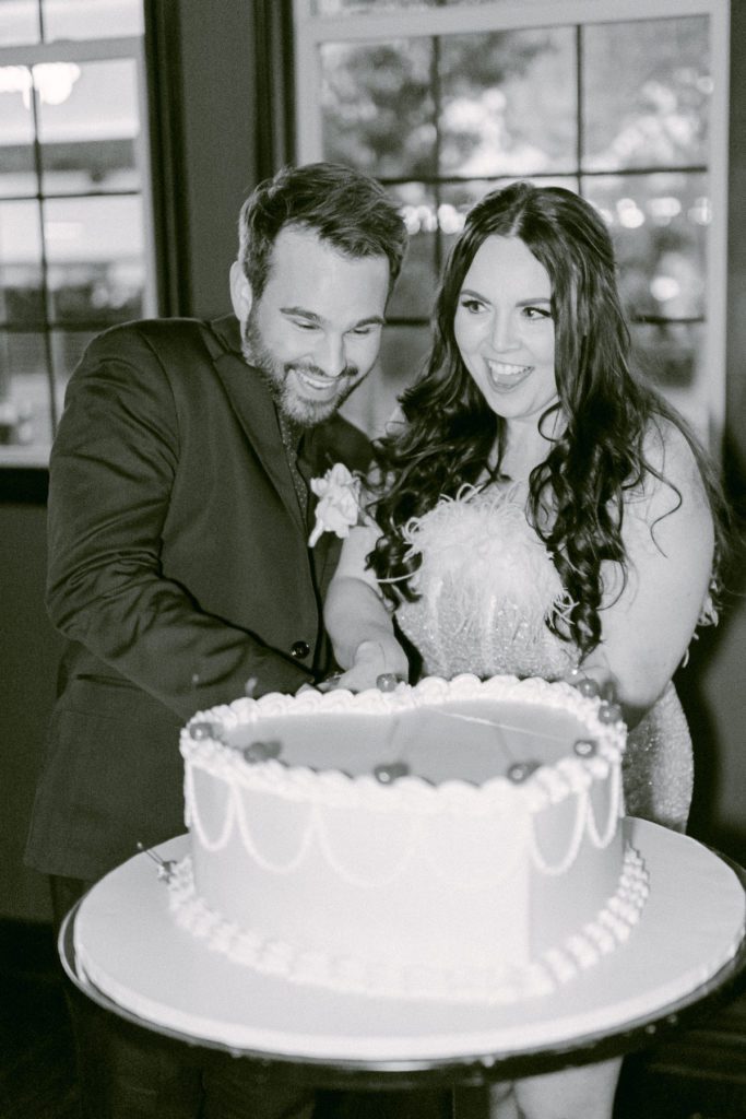 Couple cutting large heart shaped wedding cake at wedding reception at Commonwealth las vegas