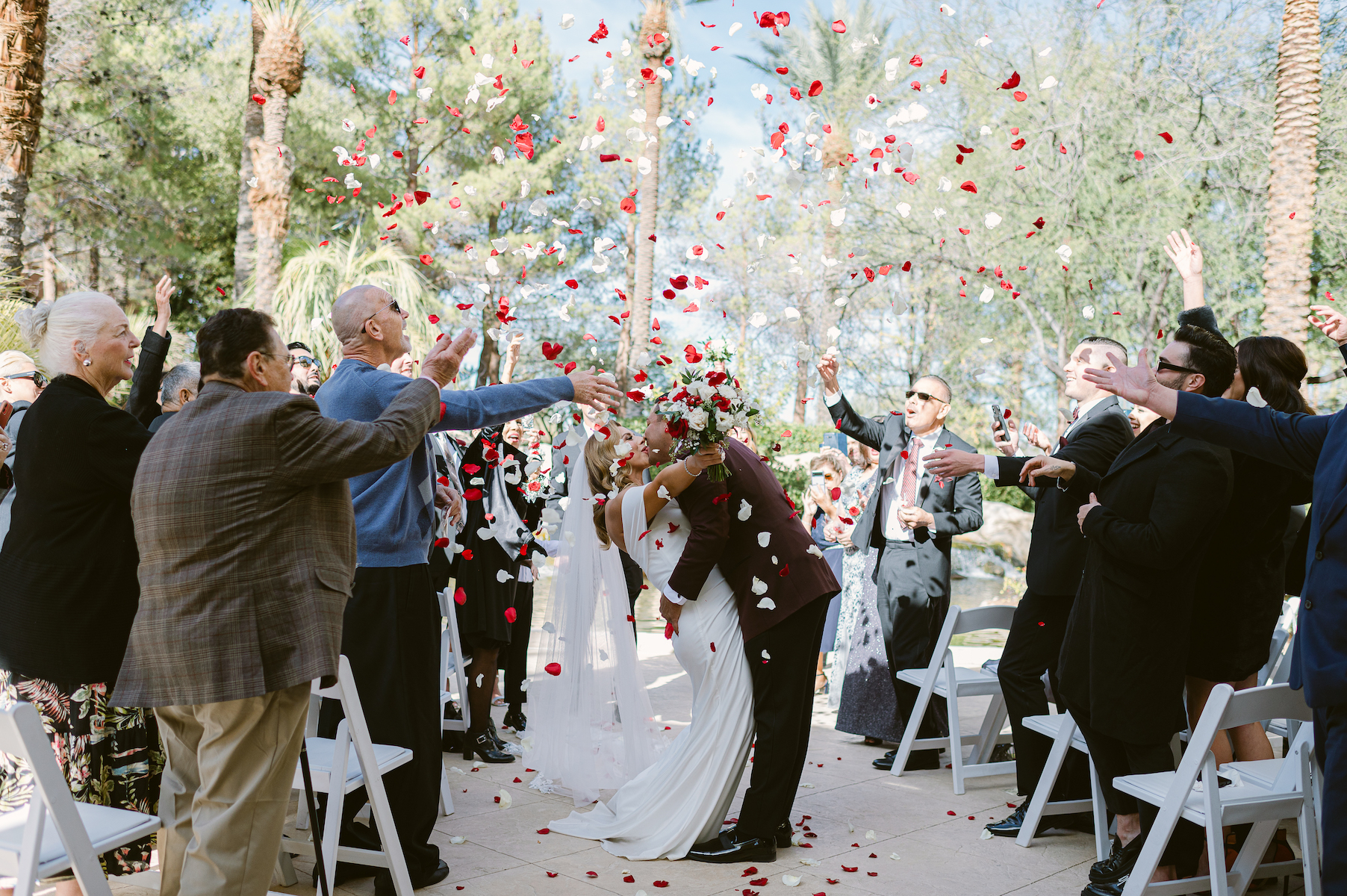 Bride and groom kiss under petal toss at Jw marriott wedding in las vegas