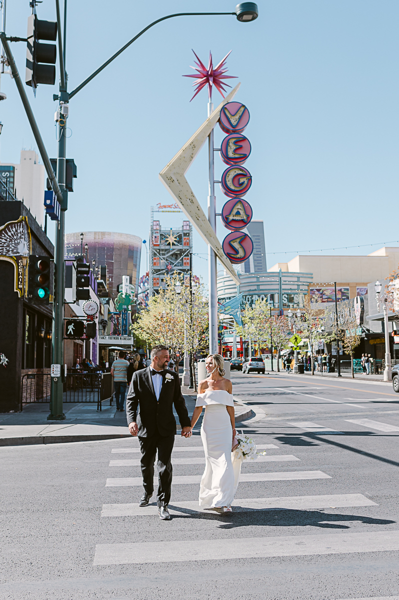 Wedding couple walking on Las Vegas Boulevard in downtown Las Vegas, NV with neon signs Las Vegas Photography Photographer