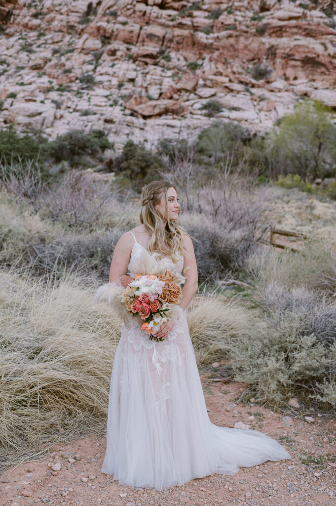 bride holding burnt orange and blush wedding bouquet in Red Rock Canyon Las Vegas Photography